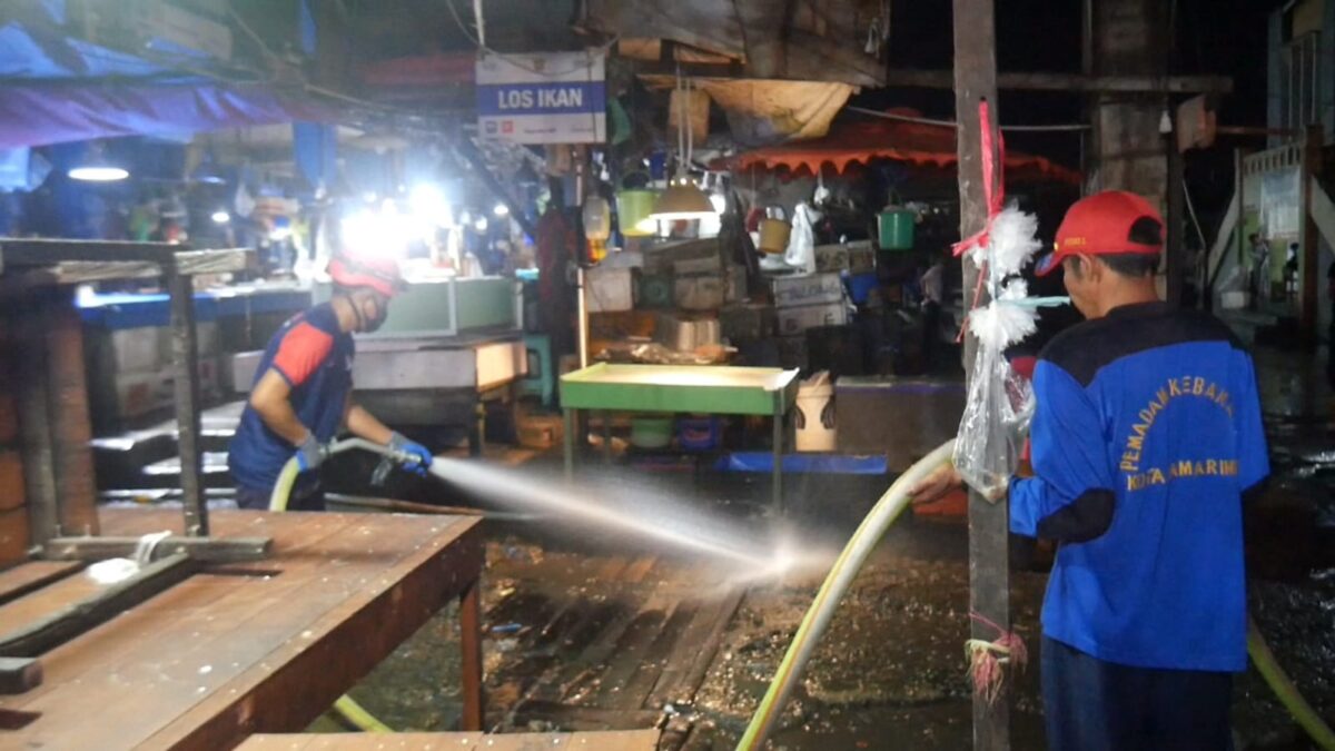 Petugas Disdamkar Kota Samarinda saat membersihkan kios-kios pedagang di Pasar Segiri. (Foto : Klausa.co)