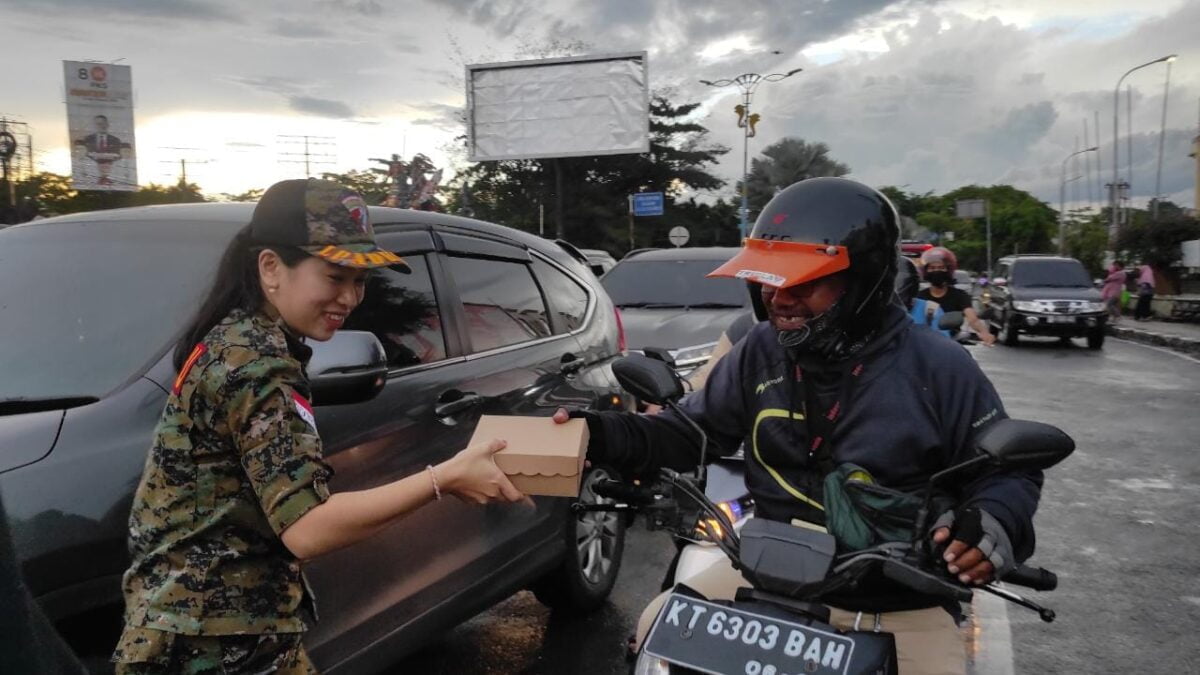 Laswan DPP LPADKT-KU saat membagikan takjil di lampu merah simpang Lembuswana. (Foto:Klausa)