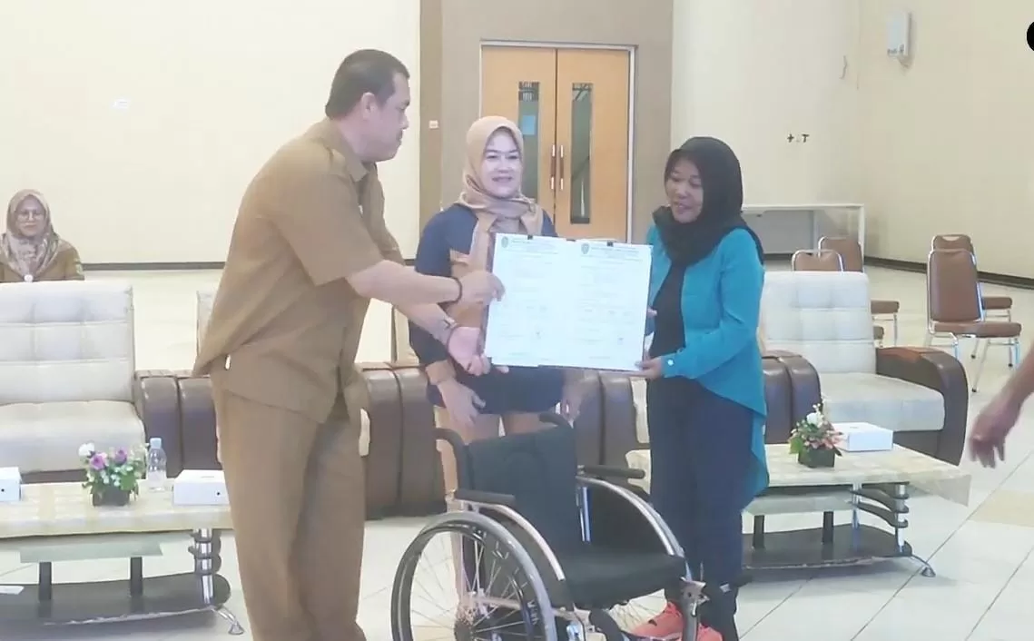 Penyerahan bantuan oleh Kabid Pembudayaan Olahraga Dispora Kaltim, AA Bagus Sugiarta, kepada pengurus National Paralympic Committe Indonesia (NPCI) PPU, Sugiarti, di Aula Dispora Kaltim (Foto: Istimewa)