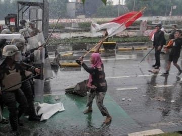 Aksi Heroik seorang Ibu di Aksi Unjuk Rasa 28 Agustus, Kibaskan Bendera Merah Putih di Hadapan Polisi.
(Foto: Instagram/cnnindonesia)