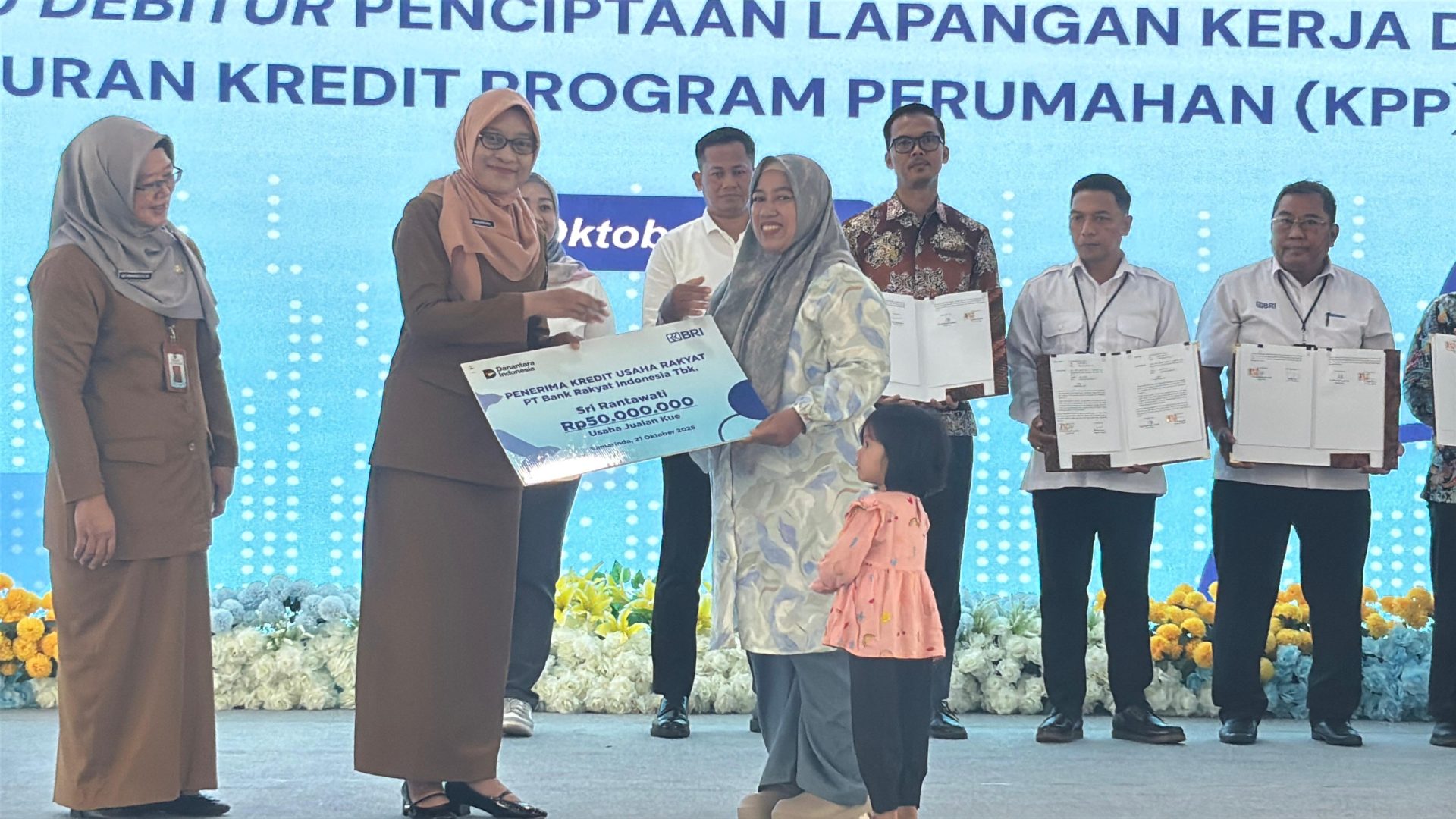 Sekdaprov Kaltim, Sri Wahyuni dan Kepala DPPKUKM Kaltim, Heni Purwaningsih saat akad penyerahan simbolis kepada debitur pelaku UMKM dari Kaltim. (Din/Klausa)